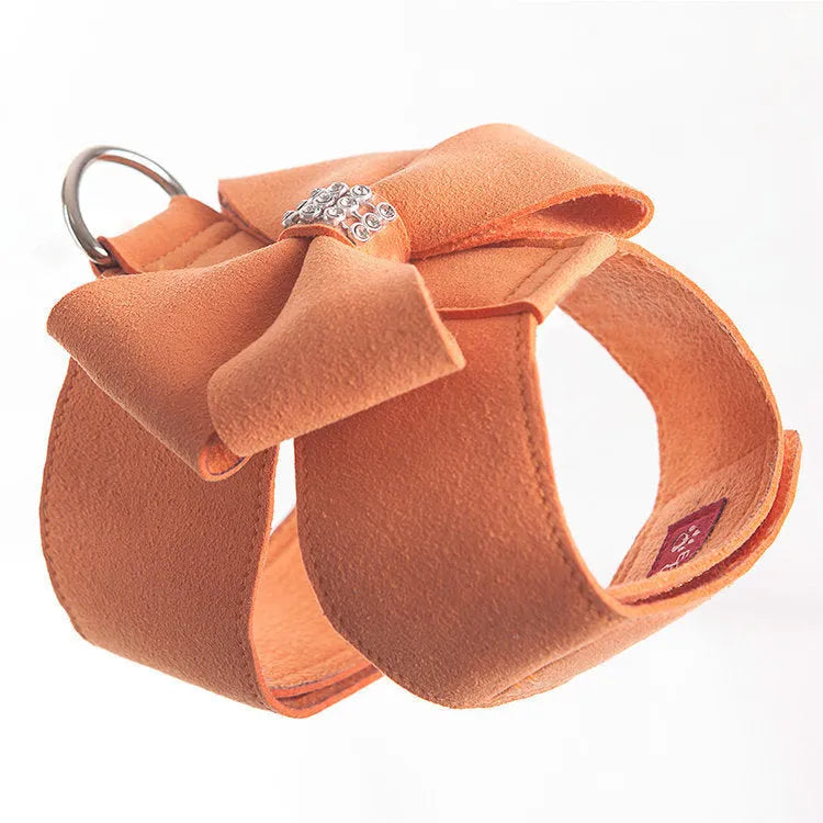 Soft pink microfiber puppy chest strap with a large white bowknot decoration laid flat.