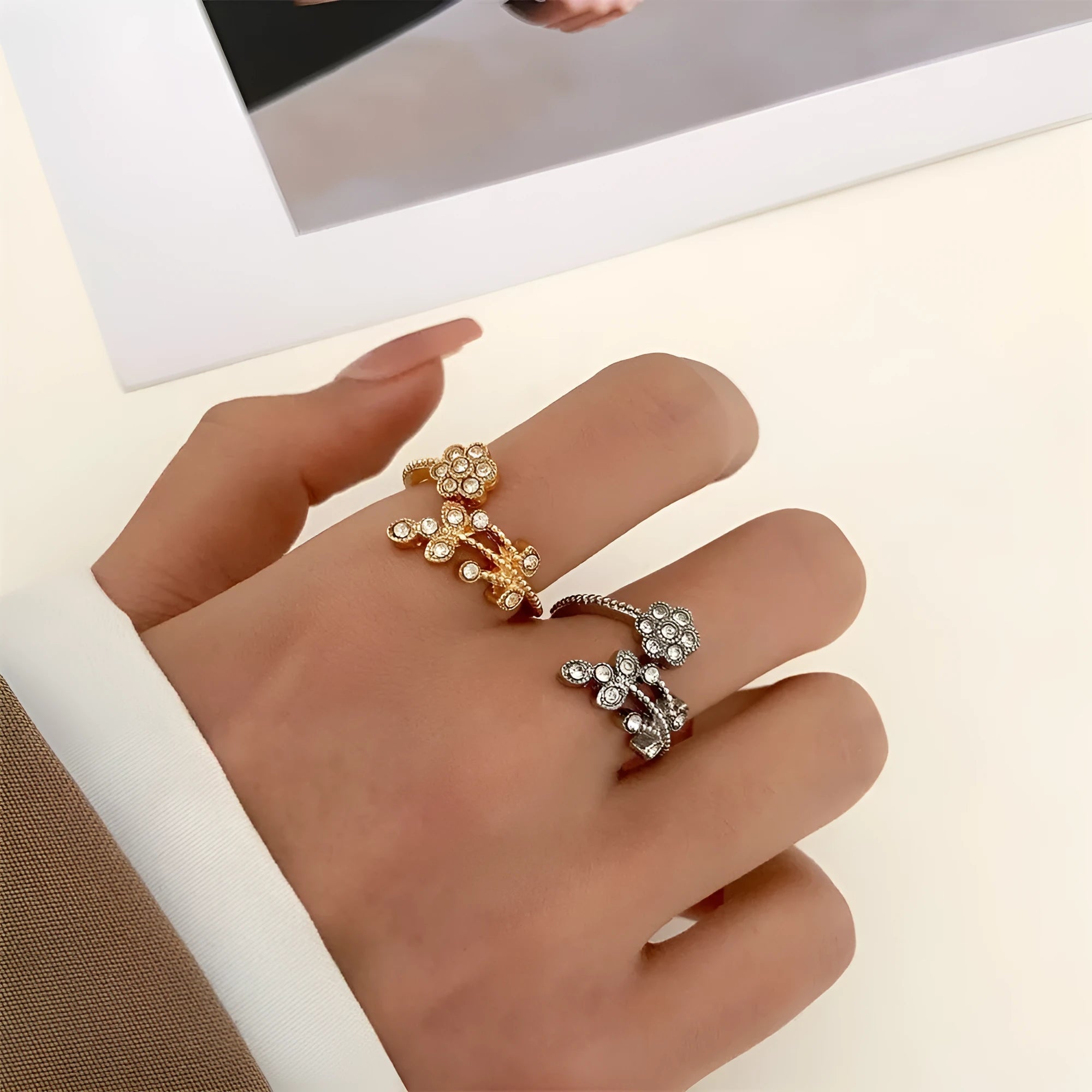 Women's open ring made of copper with a diamond finish, shaped as a detailed flower with leaves, shown in gold and white colour options.