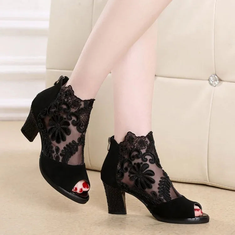Black lace gladiator sandals for women with a square high heel and peep toe, showing zip closure.