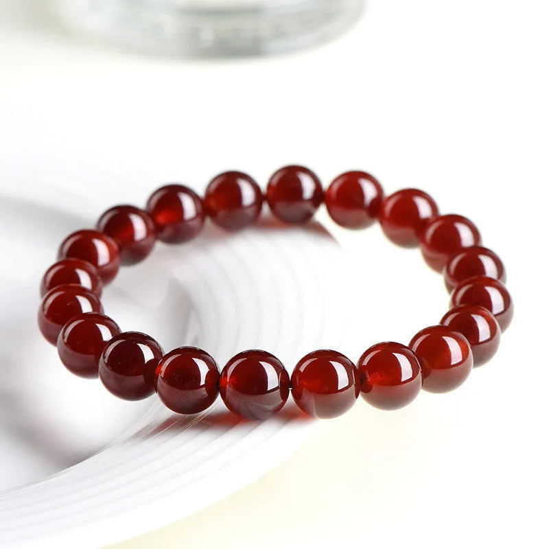 Natural orange red garnet ball bracelet with crystal beads showing ruyi pattern detailing
