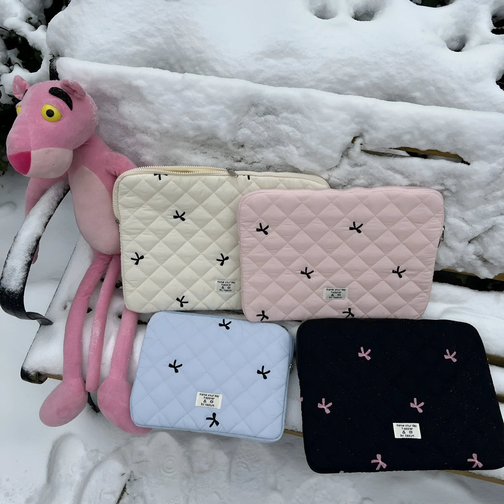Nylon laptop storage bag with embroidered rhombus bow in light blue, showing size options.