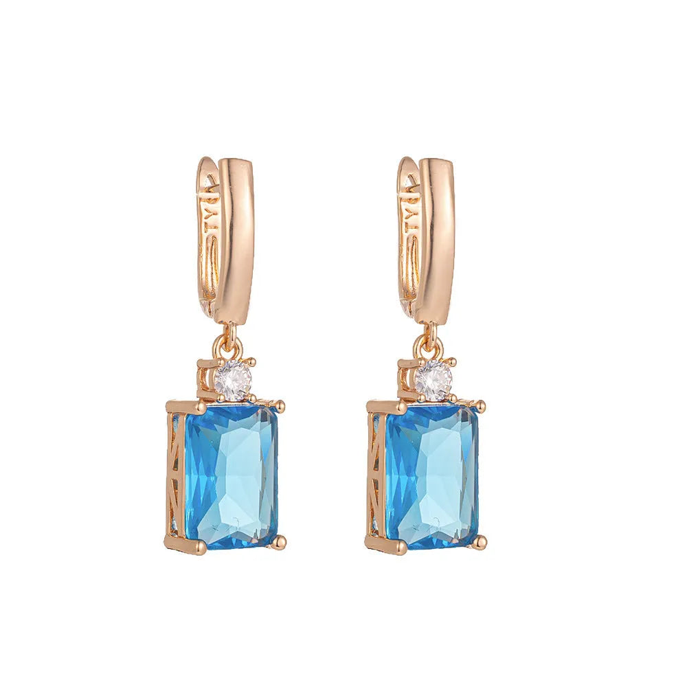 A pair of square geometric stud earrings with a gold electroplated finish on a copper base.