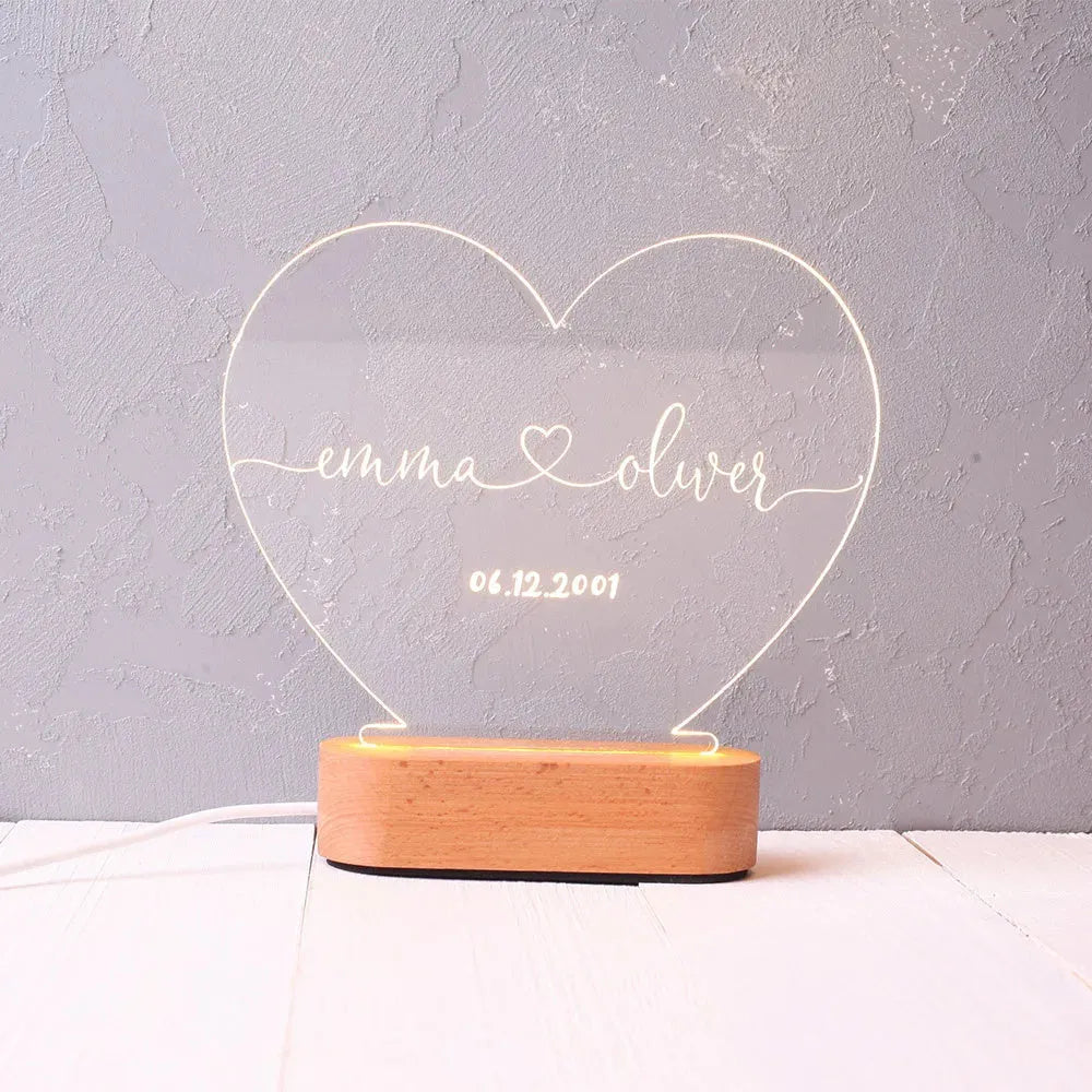 Custom engraved acrylic LED night light showing illuminated personal names and dates