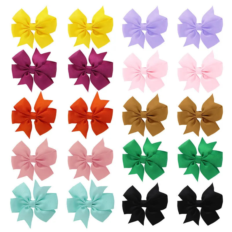 Assortment of handmade 3-inch grosgrain ribbon pinwheel hair bows with alligator clips for toddler girls in multiple colours.