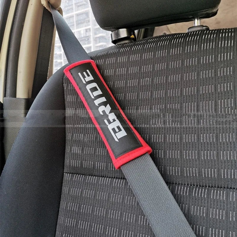 Pair of black car seat belt shoulder pads made from sponge cloth, showing embroidery detail and size.
