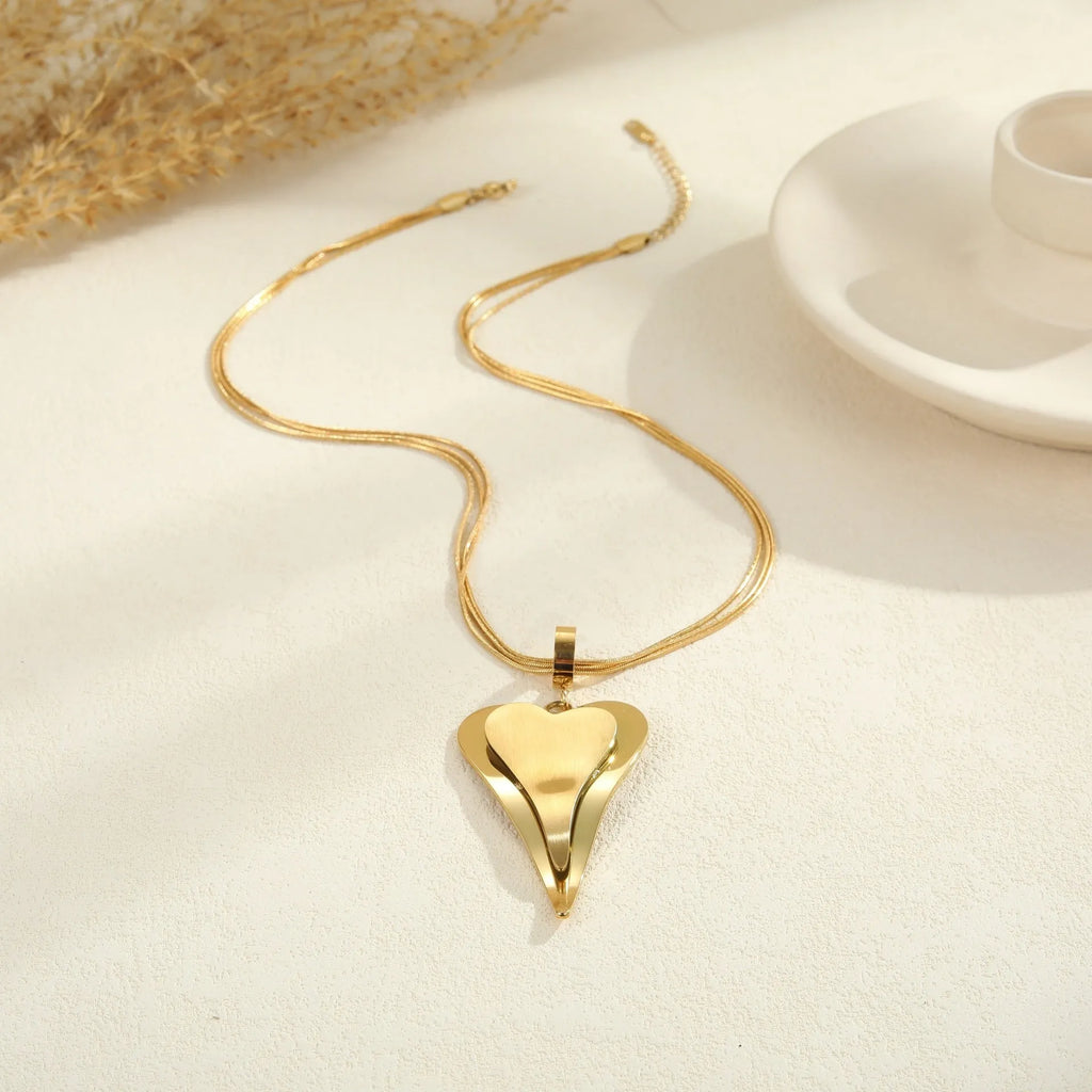 Double heart geometric pendant necklace with snake bones chain in stainless steel, shown in gold and steel colour options.