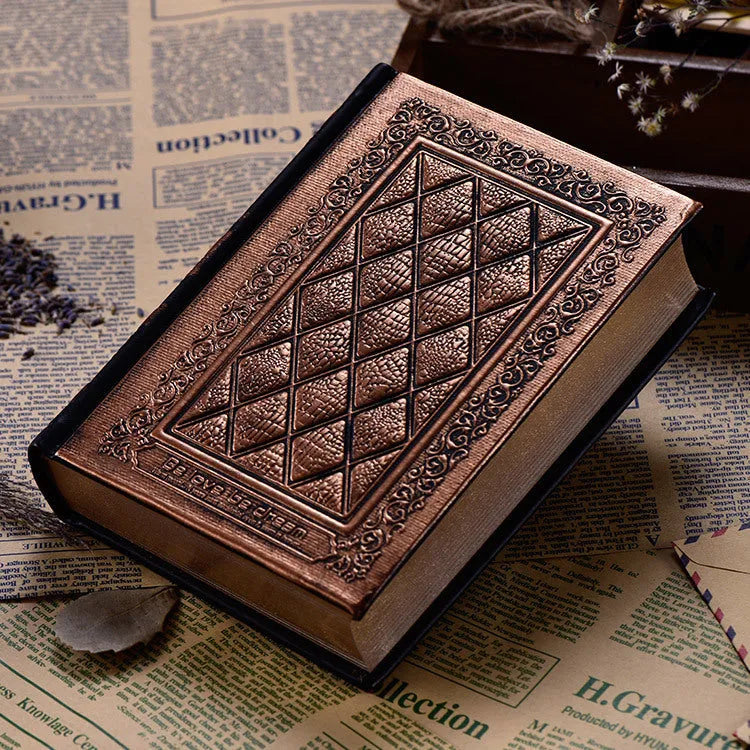 Embossed faux leather notebook in bronze colour, open to show thick white pages.