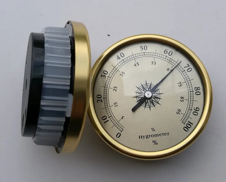 Analog thermometer and hygrometer with aluminium ring and dial showing temperature and humidity scales.