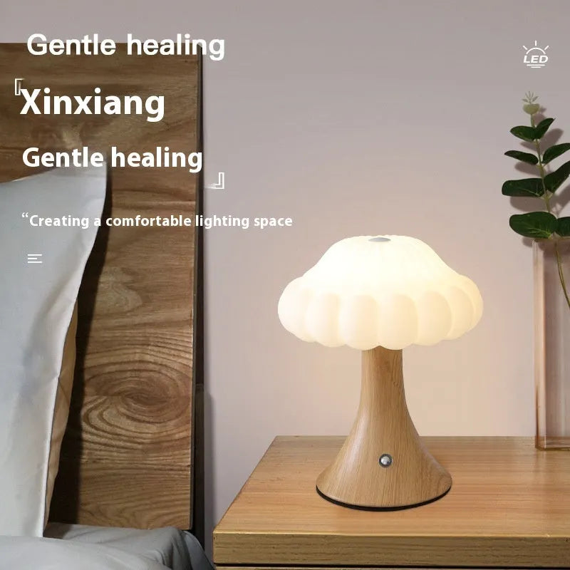 Mushroom-shaped touch control night lamp in wood grain colour on a wooden table.