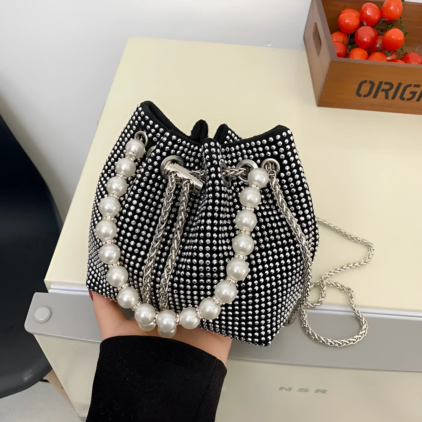 Diamond pattern crossbody bag with chain strap in bucket shape showing internal organisation compartments