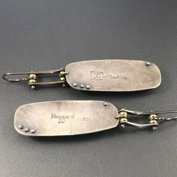 Close-up of women's geometric alloy earrings with a white and grey marble pattern.