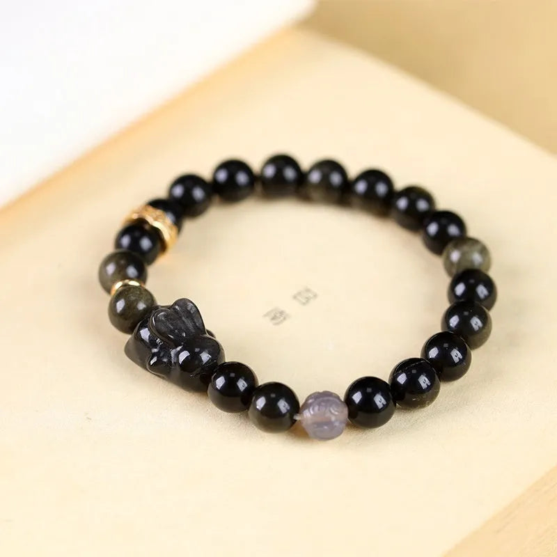 Handmade lying rabbit obsidian bracelet in brass with grey agate, showing national style design.