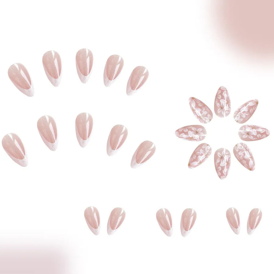 Short almond shaped faux nails with French manicure style and glittery pink flower design.