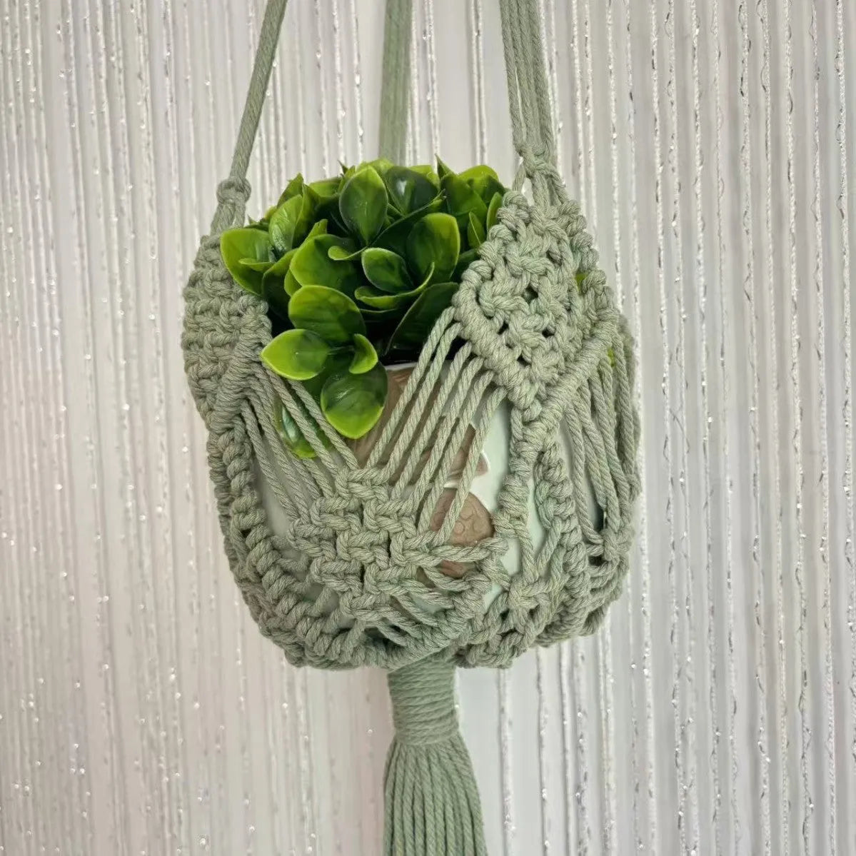 Handwoven brown polyester cotton flower pot net sleeve covering a plant pot.