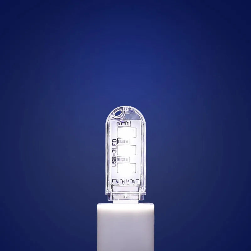 Compact round white LED night light with USB cable, shown with warm and white light illumination.