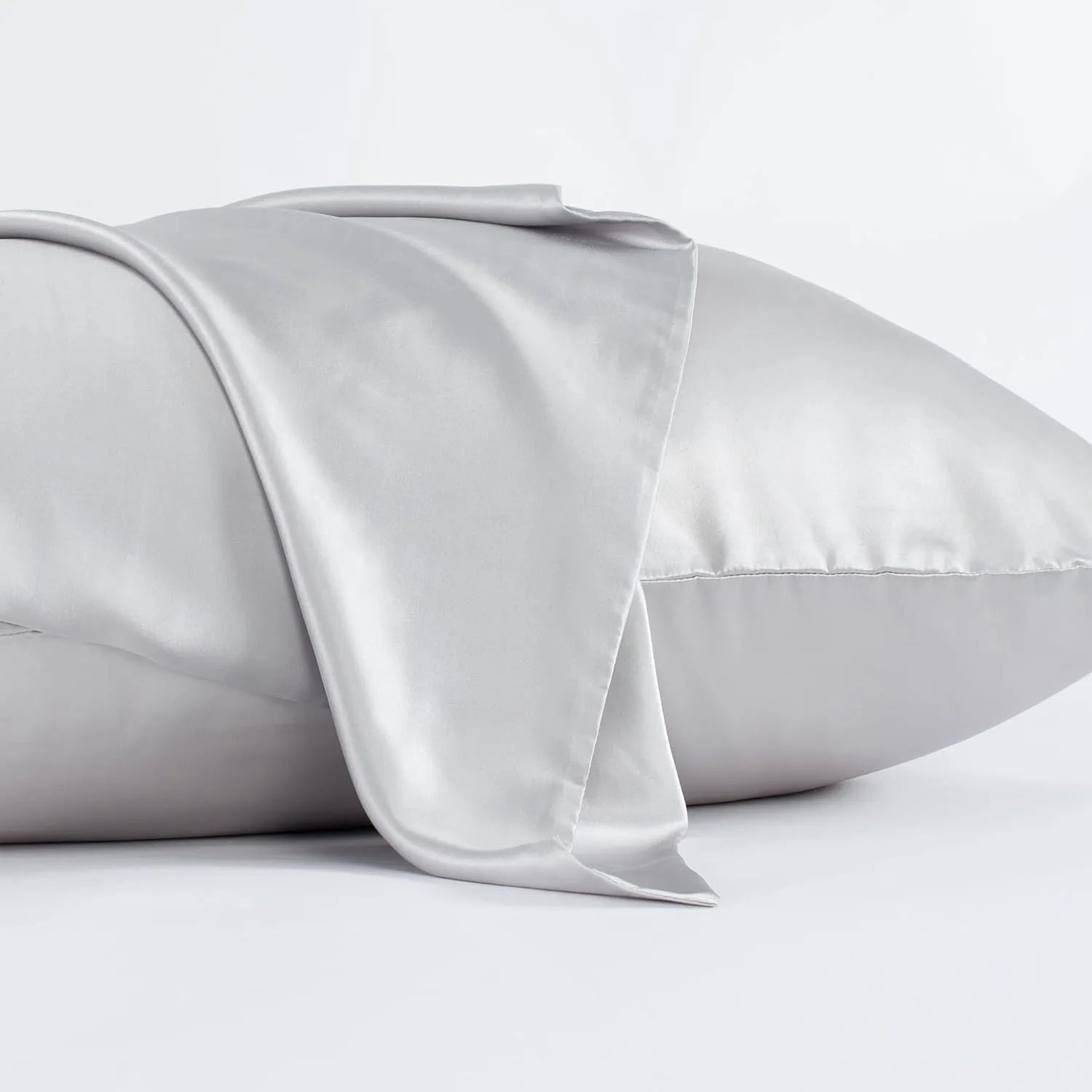 Dark grey silk pillowcase with envelope closure on a bed