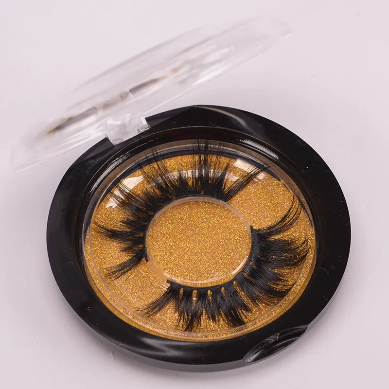 A pair of handcrafted 5D mink false eyelashes with applicator brush and storage case on a clean background.