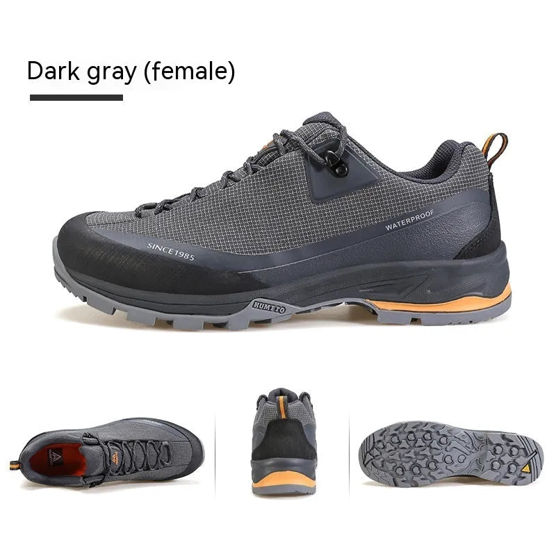 Men's low-top hiking boot in black with front lace-up, rubber outsole, and leather mesh upper.