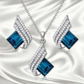Women's cross chain necklace and earrings set with glass pendant and electroplated finish.