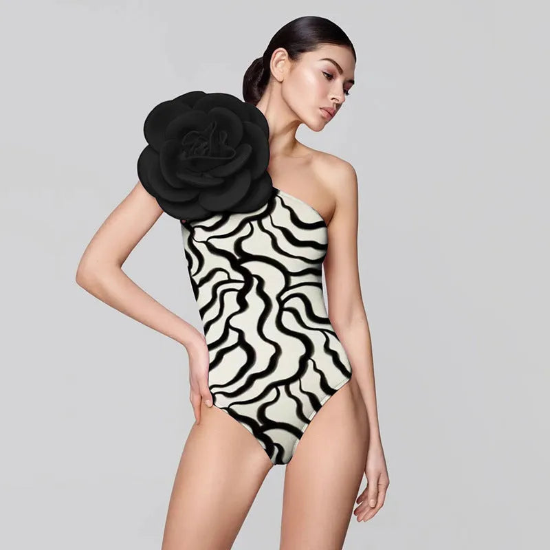 Women's one-piece swimsuit with three-dimensional floral pattern in black and blue colour options.