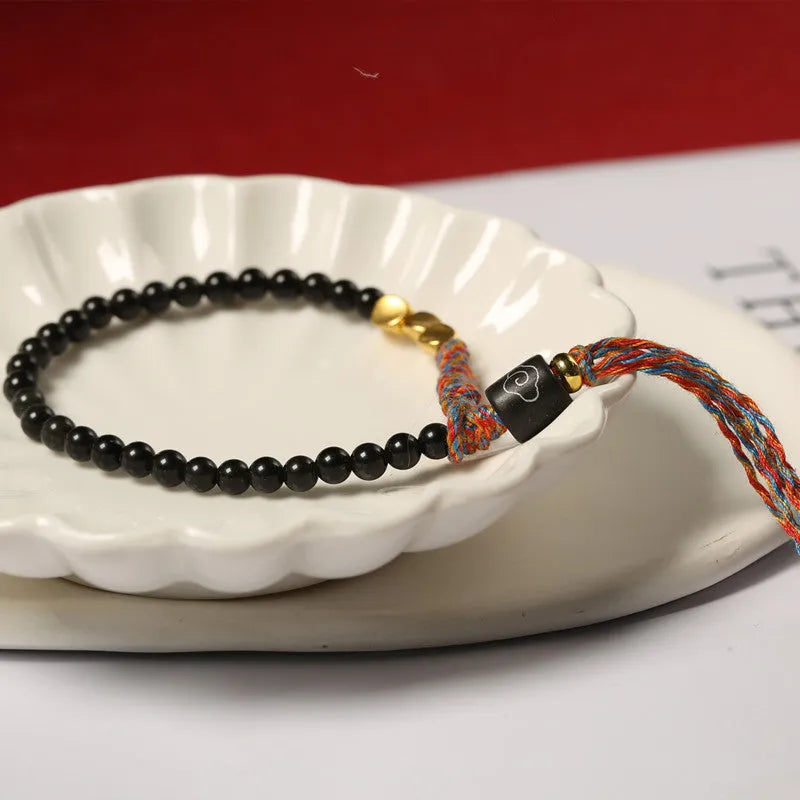 Hand-woven obsidian carrying strap bracelet showing textured weave and adjustable 15.5-16cm length
