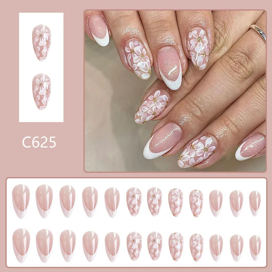 Short almond shaped faux nails with French manicure style and glittery pink flower design.