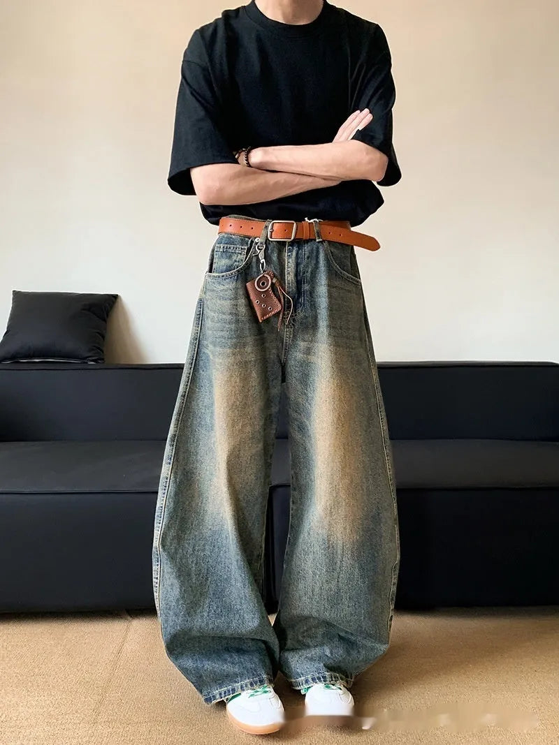 Man wearing retro blue distressed wide-leg denim jeans with a mid waist and zipper fly.