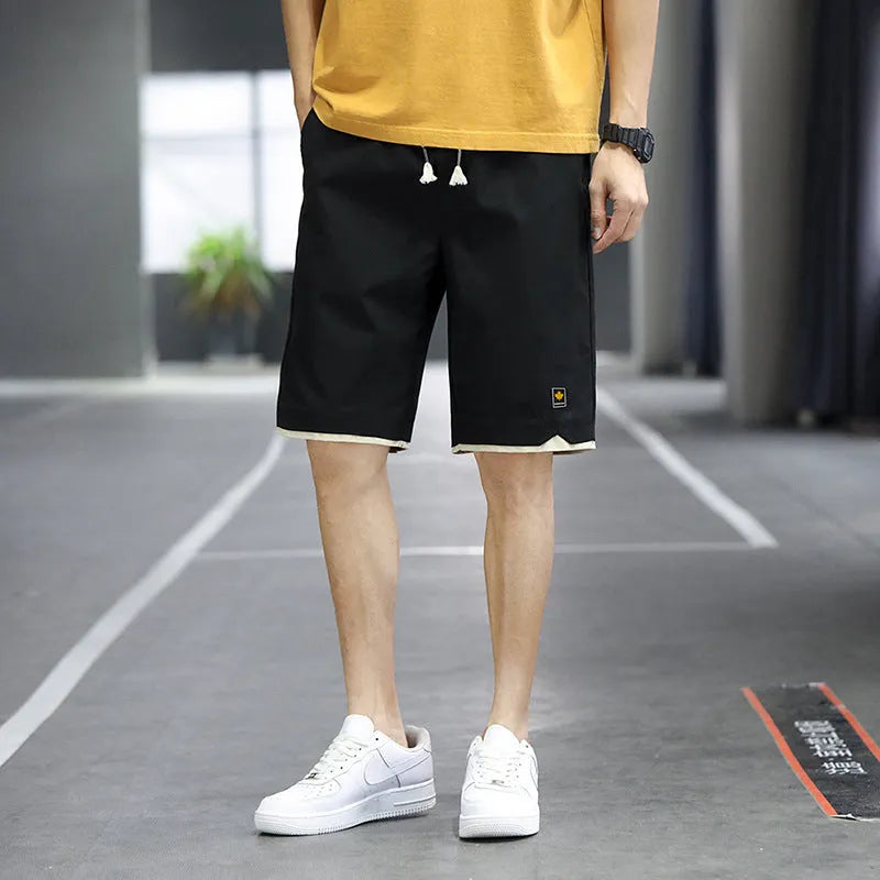 Men's straight loose fit casual beach shorts in green on a mannequin, showing elastic waistband.