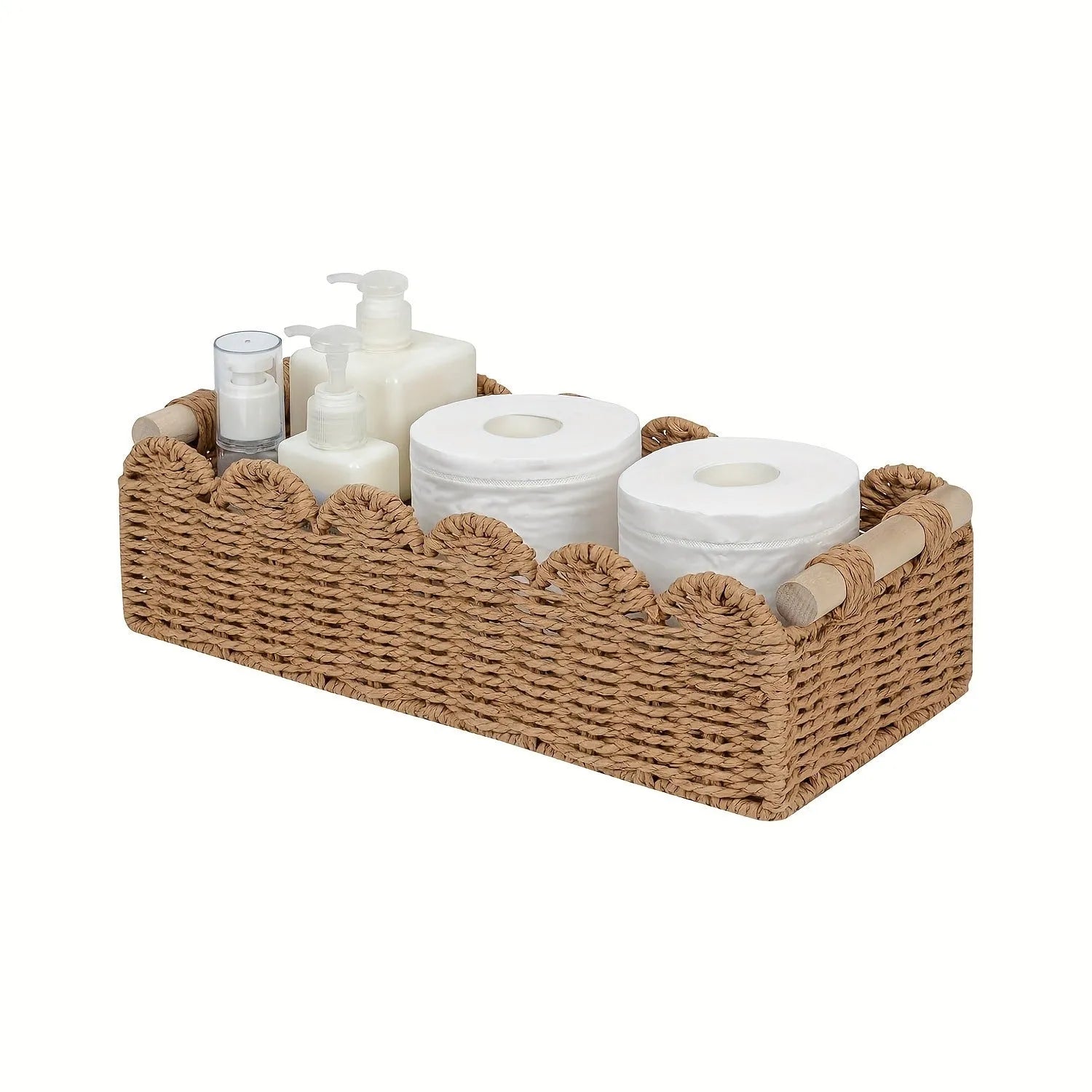 Modern woven paper storage basket in khaki colour on a wooden desktop, holding remote controls and pens.