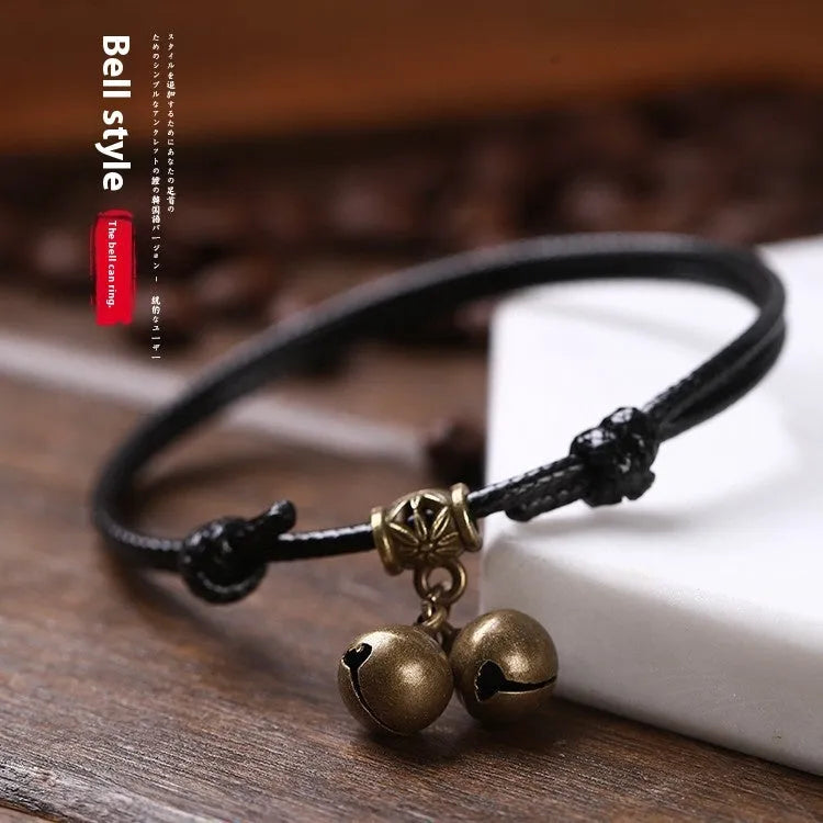 Small dog wearing adjustable nylon rope collar with brass bell in black, red, or coffee colour