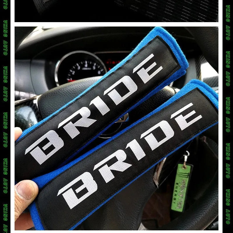 Pair of black car seat belt shoulder pads made from sponge cloth, showing embroidery detail and size.