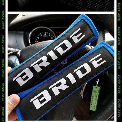 Pair of black car seat belt shoulder pads made from sponge cloth, showing embroidery detail and size.