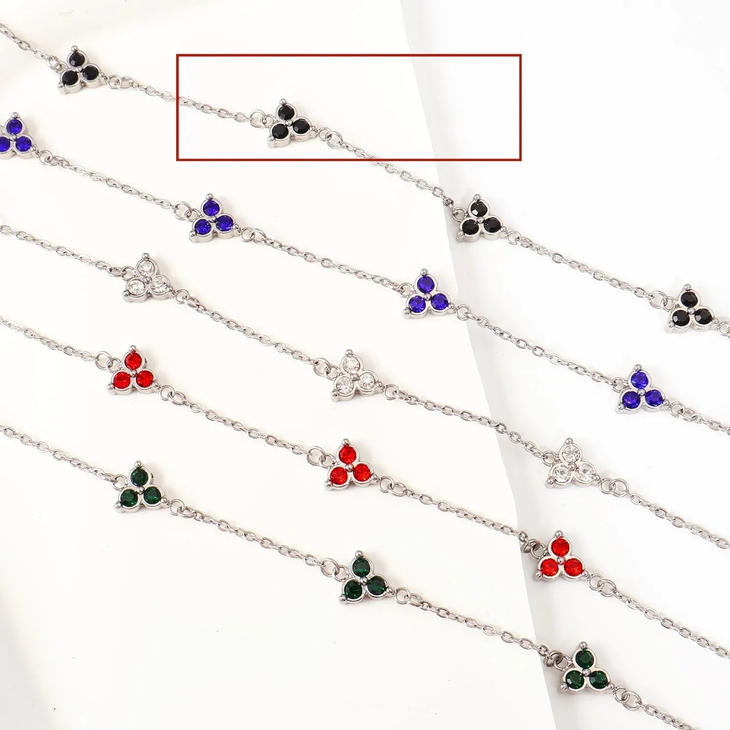 Women's stainless steel bracelet with a geometric triangle pendant, shown in gold and steel tone options with coloured stones.