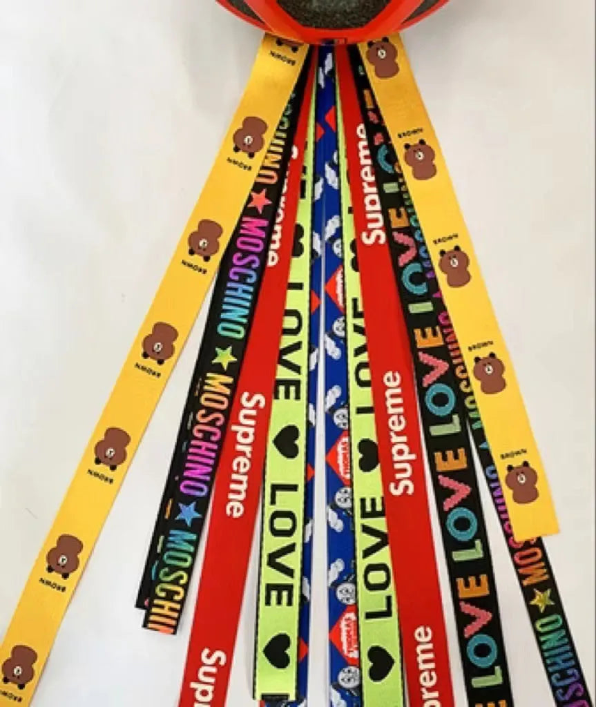 Close-up of a colourful decorative ribbon streamer attached to a child's helmet for roller skating or skiing.