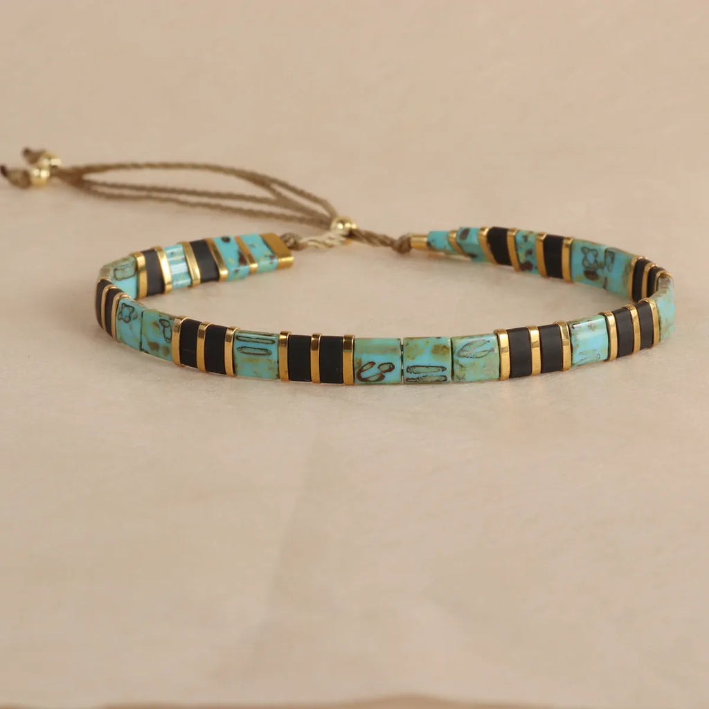 Adjustable pull beads bracelet with glass and coloured glaze beads in geometric and round shapes