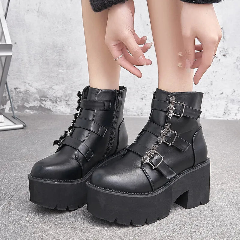 Black women's gothic punk ankle boots with a large bat-shaped buckle and a side zipper.