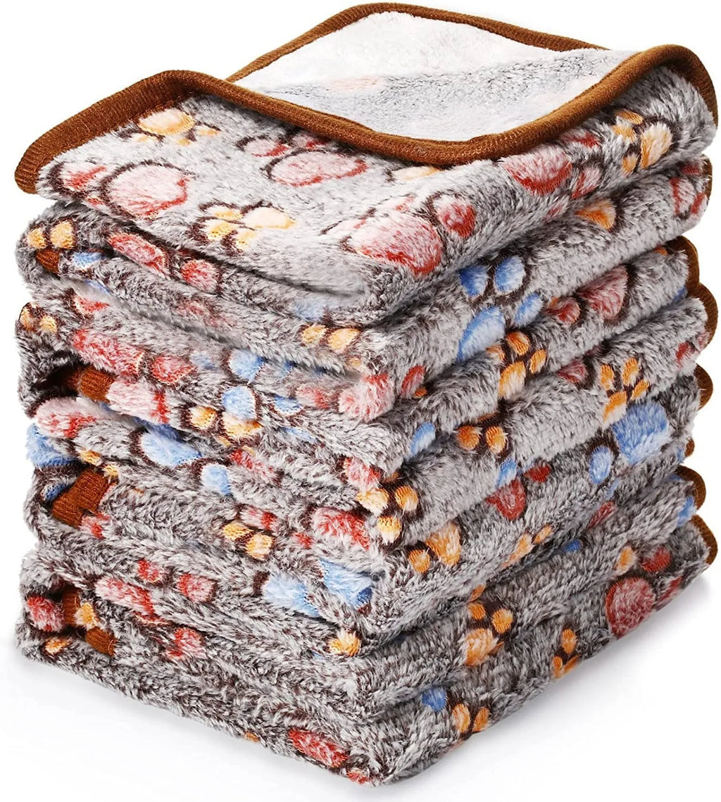 Soft coral fleece dog blanket with a paw print design, shown in a beige colour.