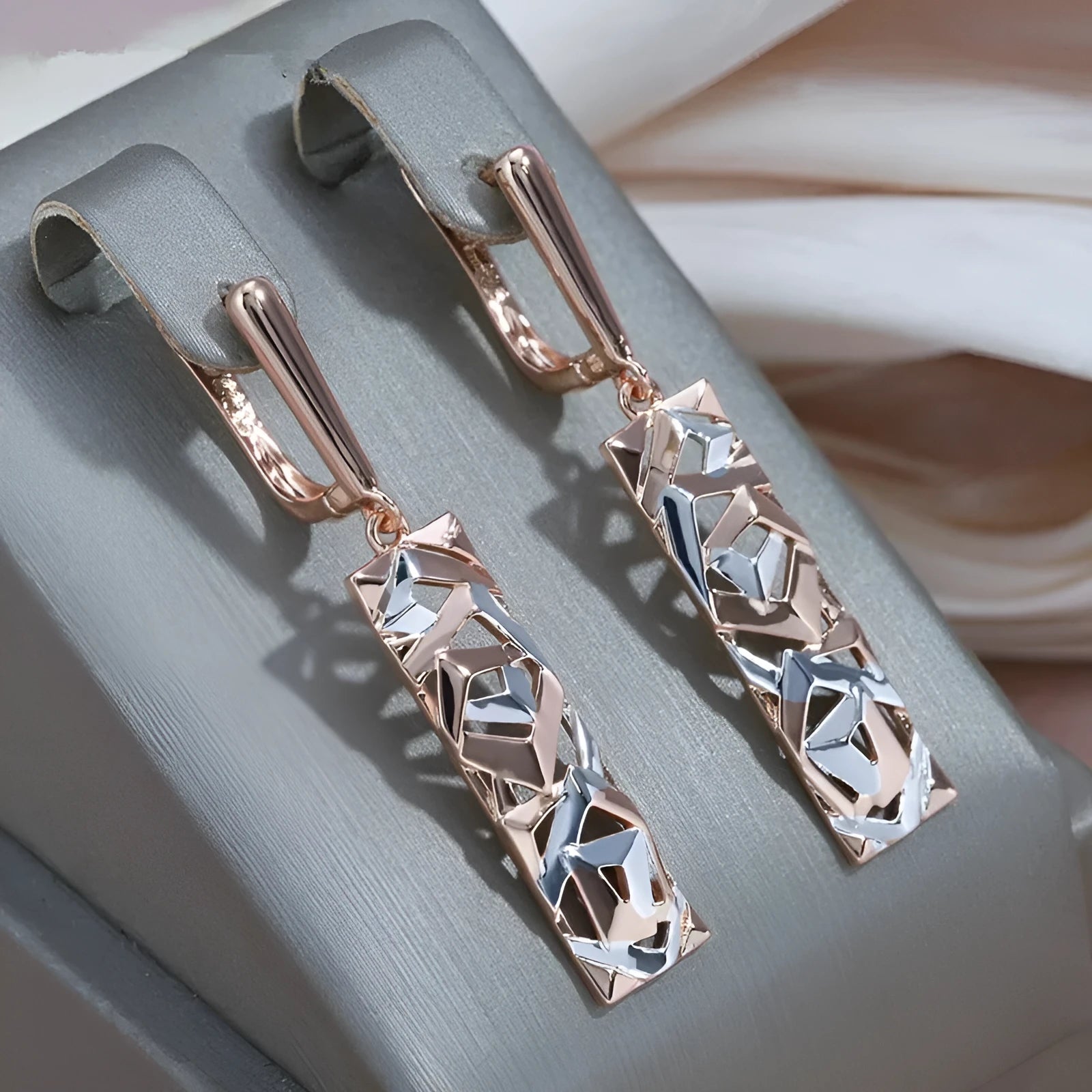 A pair of women's rectangular two-tone hollow stud earrings with a geometric design.