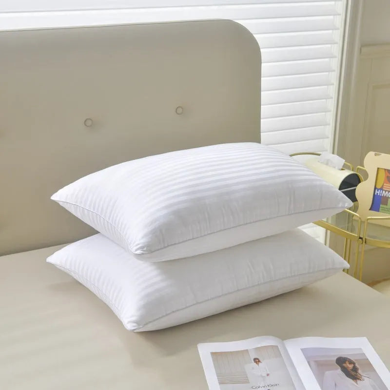 White cotton satin stripe pillow with feather and cotton filling on a bed.