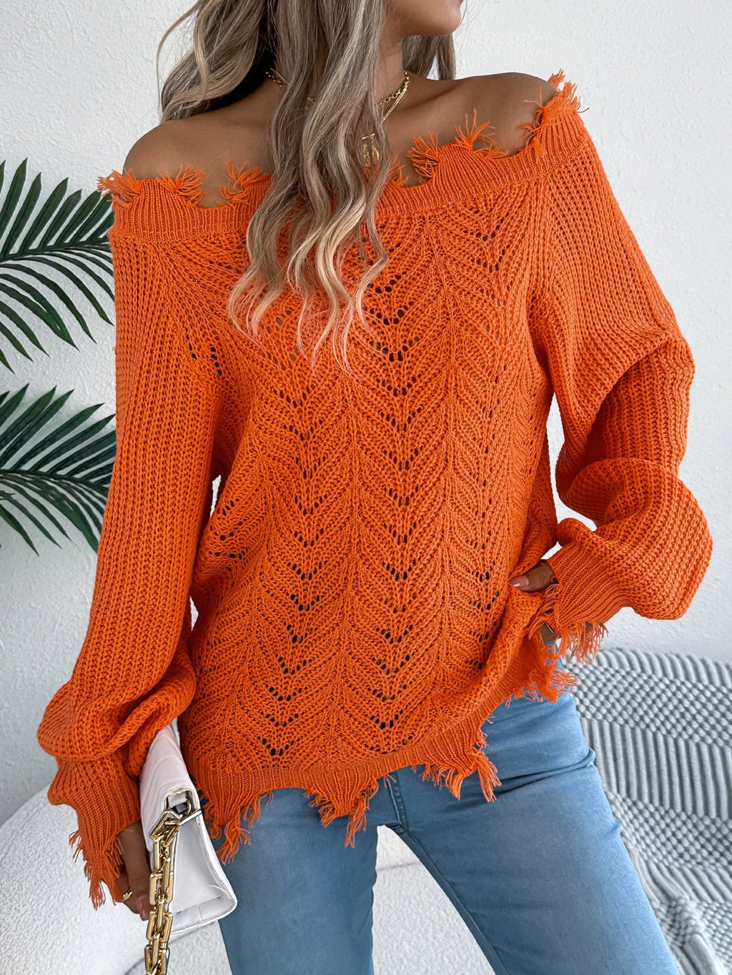 Women's white hollow-out knitted pullover sweater with cut off-the-shoulder neckline and long sleeves.