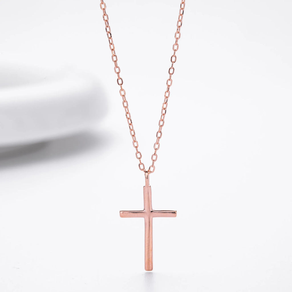 Sterling silver cross necklace with O-shaped chain in gold plating on display