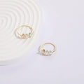 Geometric triangle birthstone ring with horse eye design and tricolour zircon stones on woman's hand