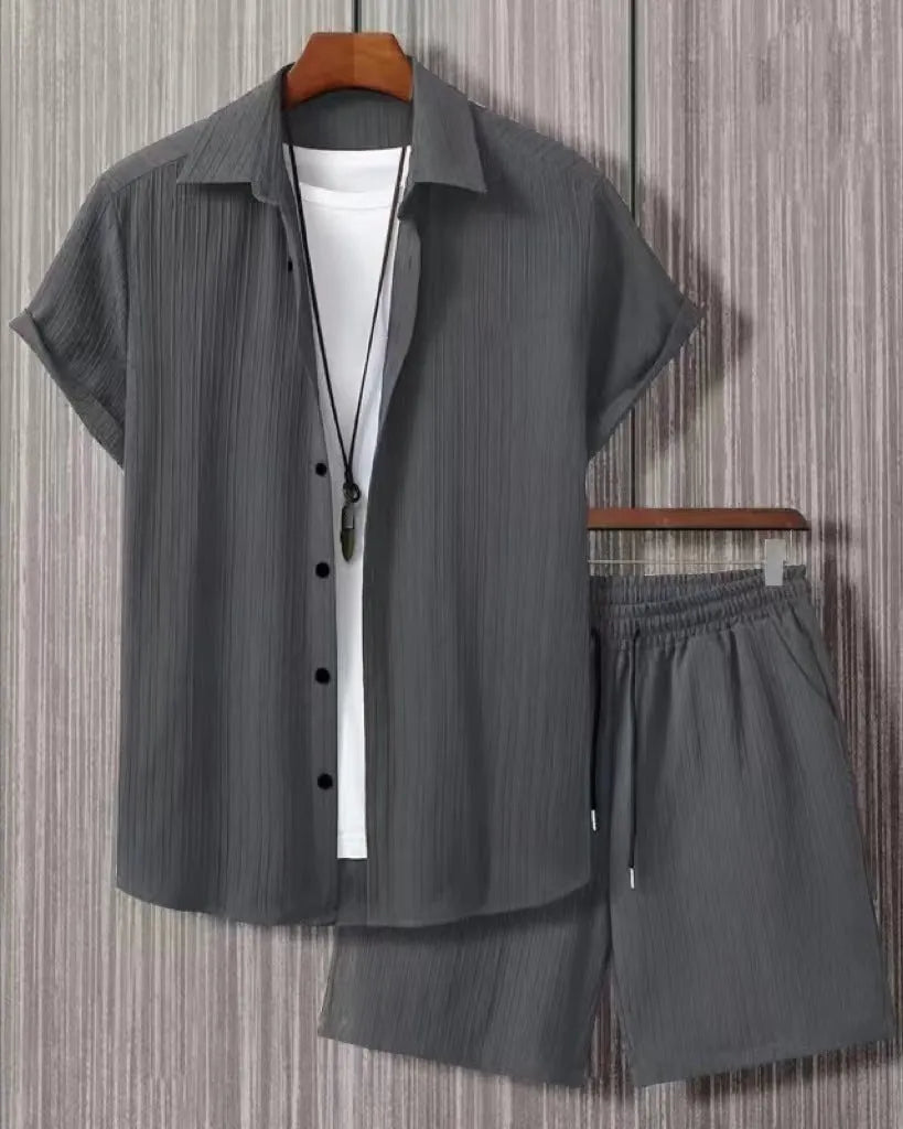 Man wearing a jacquard black short sleeve suit shirt with matching shorts from a two-piece set.