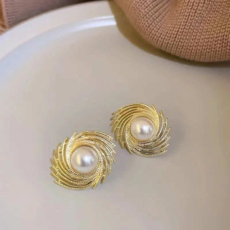 A pair of vintage floral-shaped alloy earrings with a single pearl centre and electroplated finish.