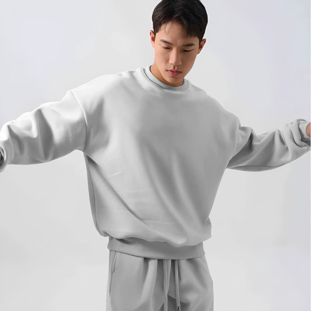 Men's black polar fleece sports suit with loose crew neck jacket and padded trousers on a hanger.