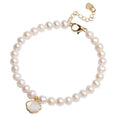 Women's freshwater pearl bracelet with central fan shell design on a wrist, showing elastic and chain fastening options.