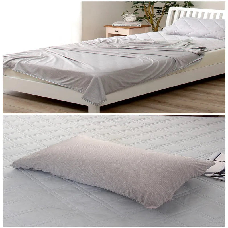 Blue Japanese cooling blanket with Q-Max fibres laid flat on a bed.