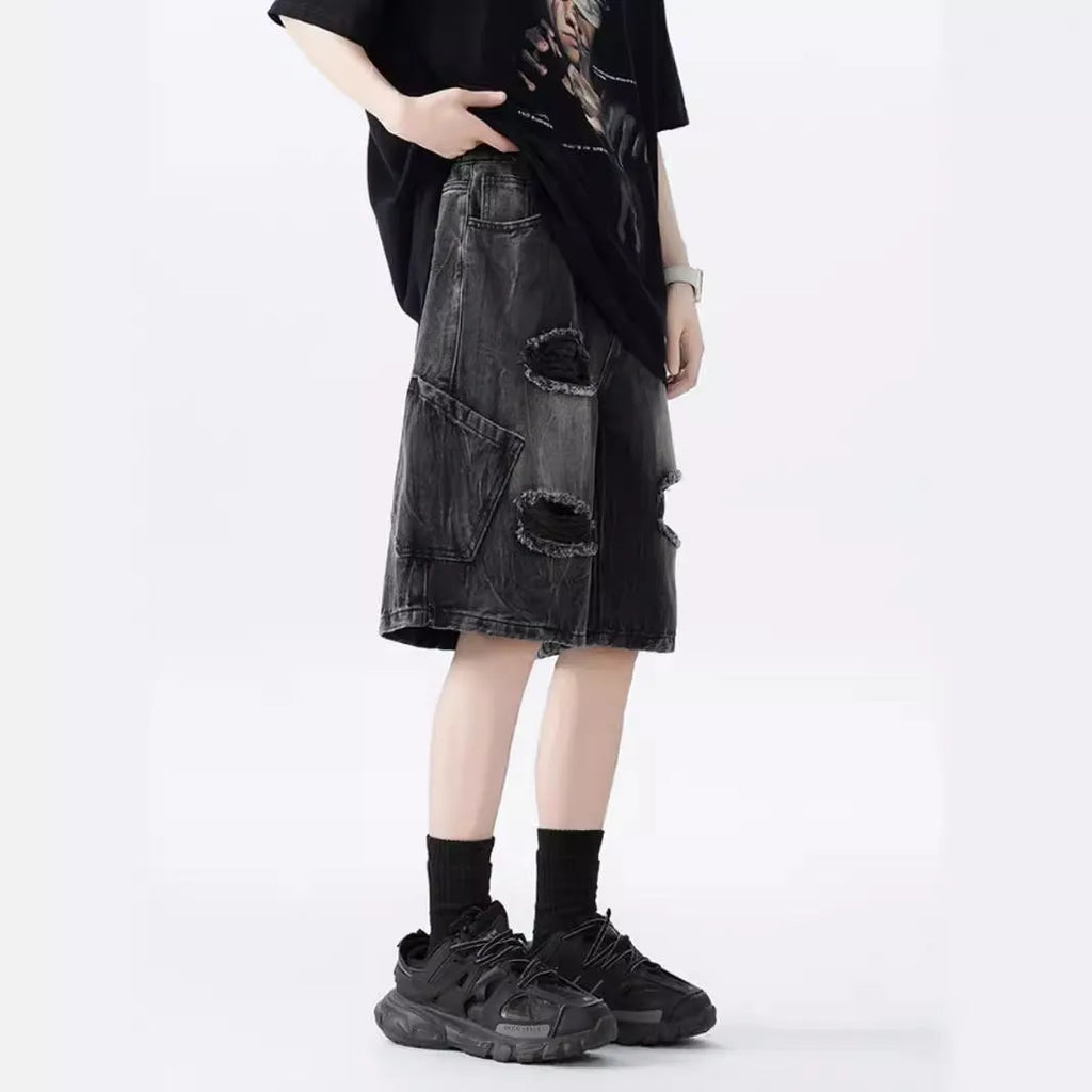 Washed black denim shorts with ripped details and loose retro fit showing front view