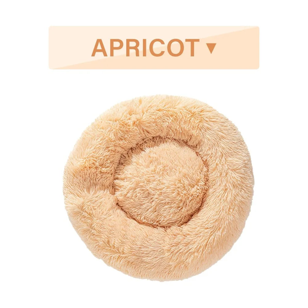 Fluffy long plush donut-shaped pet bed for dogs and cats on a wooden floor.