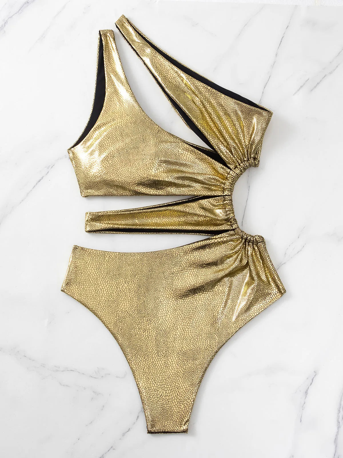 Gold coloured women's backless one-piece swimsuit on a neutral background.